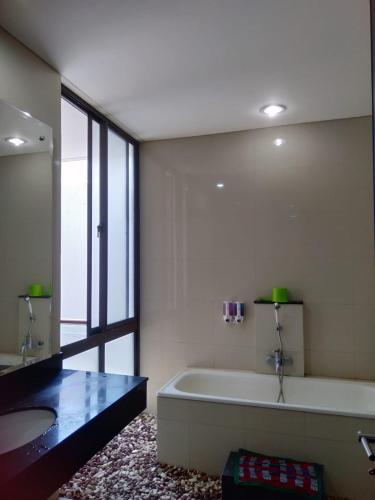 a large bathroom with a tub and a sink at Hyarta A1 in Yogyakarta