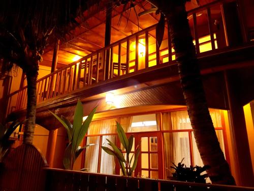 Hangnaameedhoo的住宿－繞道海灘景旅館，一座有楼梯的建筑,晚上有棕榈树