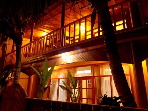 a building with a staircase and palm trees at night at Detour Beach View in Hangnaameedhoo