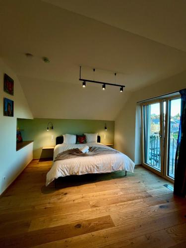 una camera da letto con un letto e una grande finestra di Gîte Koerich a Koerich
