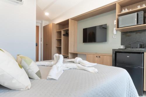 a bedroom with a bed with towels on it at Max Carneiros Suítes - Conforto e sofisticação há alguns passos do mar! in Tamandaré