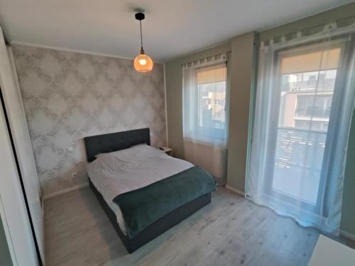 una piccola camera da letto con un letto e due finestre di Vivo Metro Amethyst noua noua a Floreşti