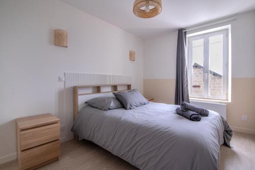 ein Schlafzimmer mit einem großen Bett und einem Fenster in der Unterkunft La Parenthèse - Proche Puy du Fo u - 2 appartements équipés et confortables au coeur des Herbiers in Les Herbiers