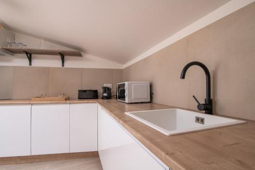 eine Küche mit Spüle und Mikrowelle in der Unterkunft La Parenthèse - Proche Puy du Fo u - 2 appartements équipés et confortables au coeur des Herbiers in Les Herbiers