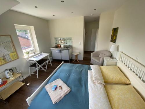 a bedroom with a blue bed and a desk and a table at Bed and Breakfast Orange-Inn in Krefeld