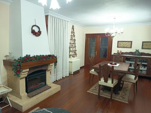 a living room with a fireplace and a dining table at Casona La Zampuca in Gijón