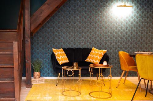 ein Wohnzimmer mit einem Sofa sowie 2 Tischen und Stühlen in der Unterkunft l'écrin du désir in Capestang