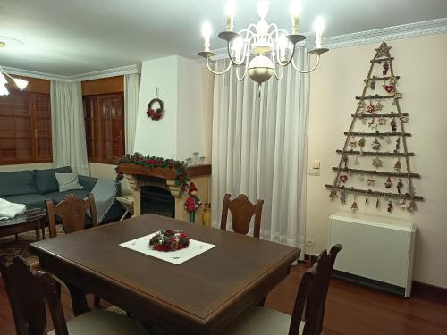 a living room with a table and a christmas tree at Casona La Zampuca in Gijón