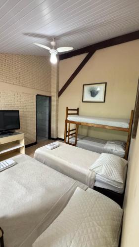 a hotel room with two beds and a television at Chacara Descanso do Rei in Vinhedo