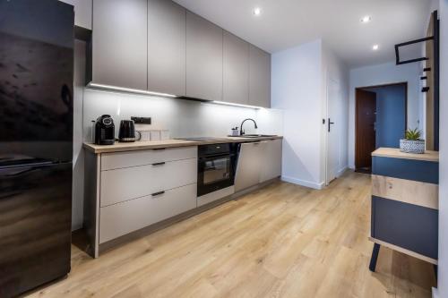 una cucina con elettrodomestici in acciaio inossidabile e pavimenti in legno di Apartamenty Moniuszki 4 a Bielsko-Biała
