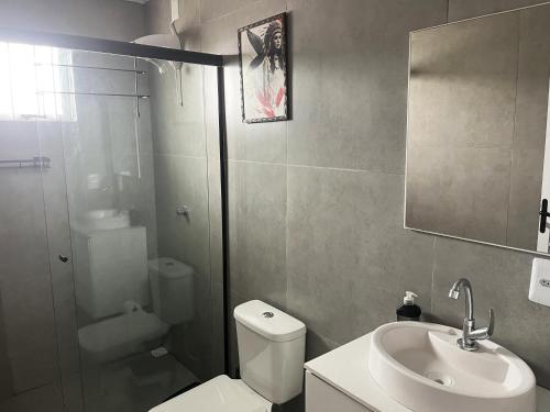 ein Badezimmer mit Toilette, Waschbecken und Dusche in der Unterkunft Havana Flats in Balneário Gaivotas