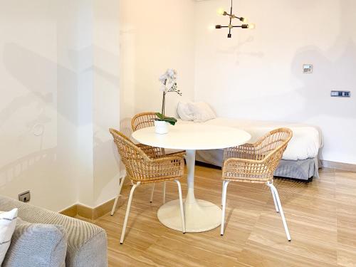 Una mesa blanca y sillas en una habitación con cama en Escapada de lujo en Resort de Isla del Fraile, en Águilas