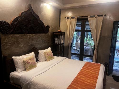 Kad Sala Homestay في Ban Nong Wai: غرفة نوم بها سرير مع ملاءات ووسائد بيضاء