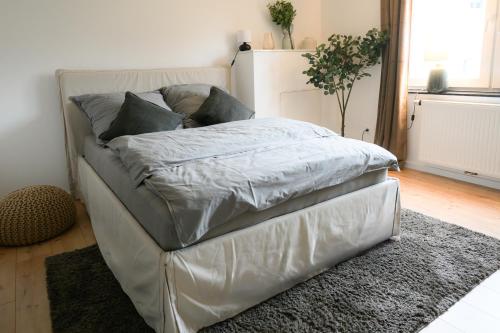 a white bed with pillows on it in a room at Elegantes Apartment in Bad Pyrmont