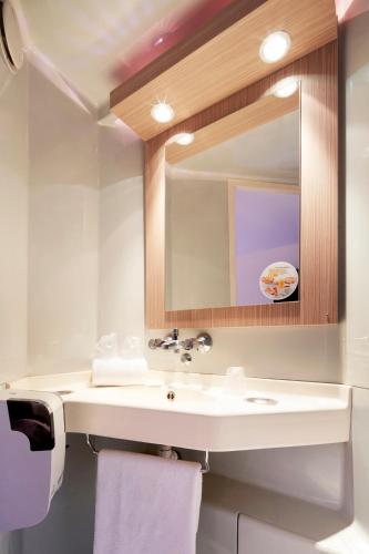 a bathroom with a sink and a mirror at Premiere Classe Poitiers Futuroscope - Chasseneuil in Chasseneuil-du-Poitou
