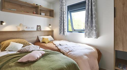 En eller flere senge i et værelse på Camping Le Coin Charmant