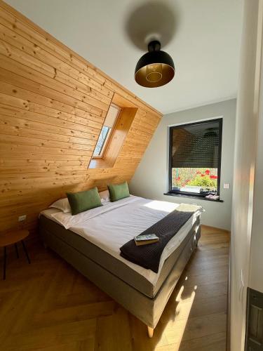 a bedroom with a bed in a wooden wall at AHA Cabin in Comarnic