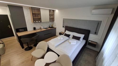ein Schlafzimmer mit einem Bett und einem Schreibtisch mit einem Computer in der Unterkunft Studio apartman OAZA in Vukovar