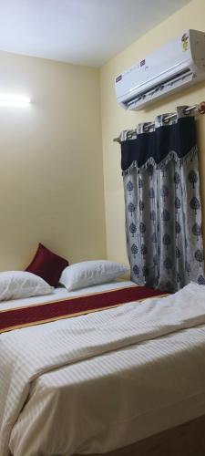 Una habitación de hotel con una cama con abertura. en AKR Homestay, en Tiruvannāmalai