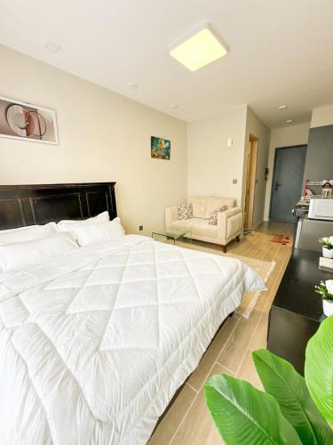 a bedroom with a large white bed and a couch at Cozystays by Vee Near JKIA in Nairobi