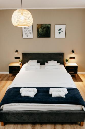 a bedroom with a large bed with two towels at Lusia Apartment in Jarosław