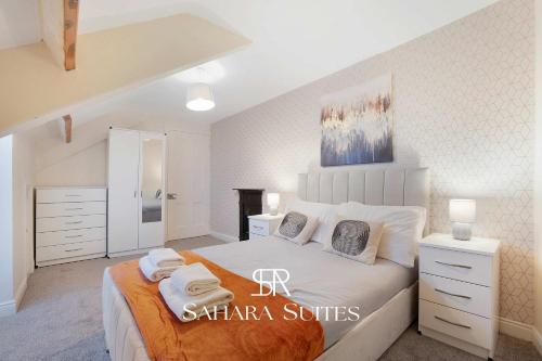 ein Schlafzimmer mit einem großen Bett, auf dem Handtücher liegen in der Unterkunft Stylish 4BR South Shields Home - Contractors & Family Stay in Westoe