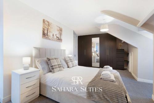 ein Schlafzimmer mit einem weißen Bett und einer Treppe in der Unterkunft Stylish 4BR South Shields Home - Contractors & Family Stay in Westoe