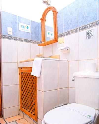 a bathroom with a toilet and a sink and a mirror at Hotel Las Fuentes in Los Mochis