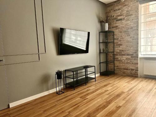 a living room with a table and a television on a wall at Kobylianska-Premium 2 Room in Chernivtsi