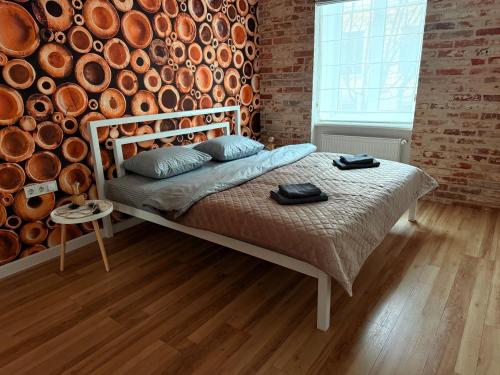 a bed in a room with a brick wall at Kobylianska-Premium 2 Room in Chernivtsi