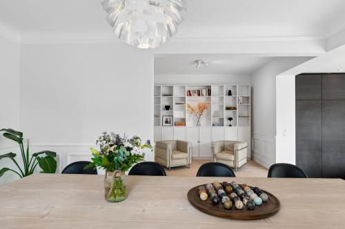 a dining room table with chairs and a vase of flowers at Villa in the Heart of Aarhus in Aarhus
