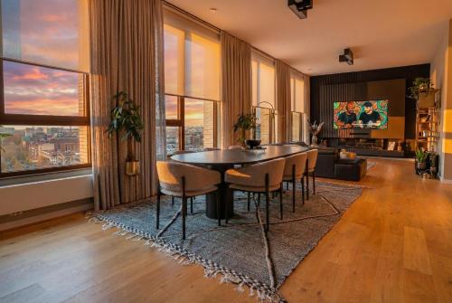 a dining room with a table and chairs in a living room at Sunset Penthouse Antwerp in Antwerp