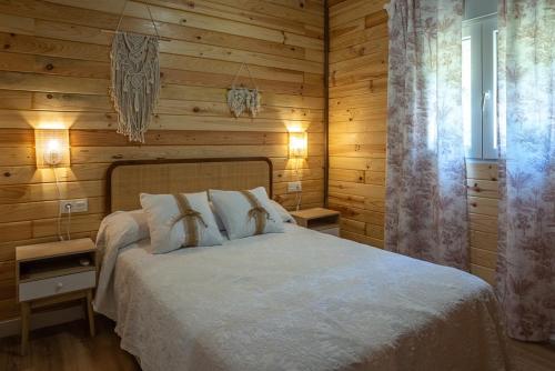 a bedroom with a white bed with wooden walls at casa Villa Escondida in Cádiz