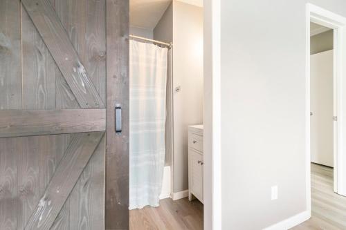 a bathroom with a wooden sliding shower door at Nole Worries! in Tallahassee