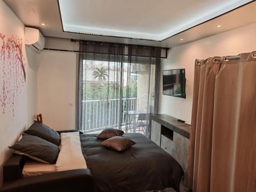 a bedroom with a bed with pillows and a window at Dolce vita in Menton