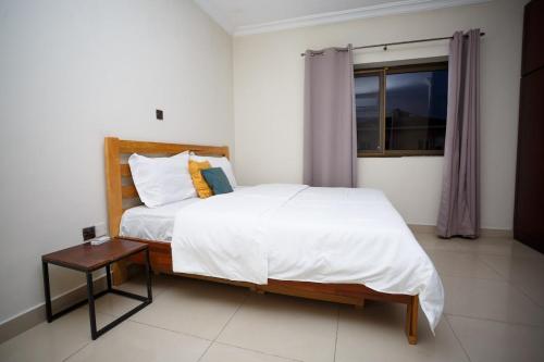 una camera da letto con un letto, un tavolo e una finestra di Ocean Heights - One Bedroom a Accra