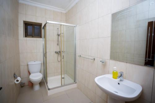un bagno con doccia, WC e lavandino di Ocean Heights - One Bedroom a Accra