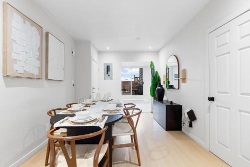 a white dining room with a table and chairs at Boho Luxe 2-Floor Retreat Sleeps 6 Private Patio in Montréal
