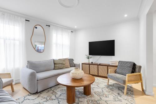 a living room with a couch and a tv at Boho Luxe 2-Floor Retreat Sleeps 6 Private Patio in Montréal