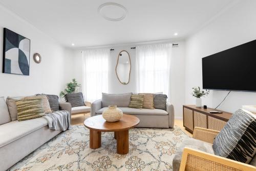 a living room with a couch and a table at Boho Luxe 2-Floor Retreat Sleeps 6 Private Patio in Montréal