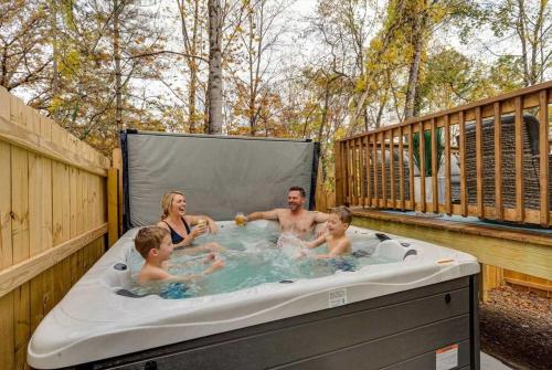 a family in a hot tub on a deck at Family-Friendly Home w Hot Tub Fire Pit Games in North Glade