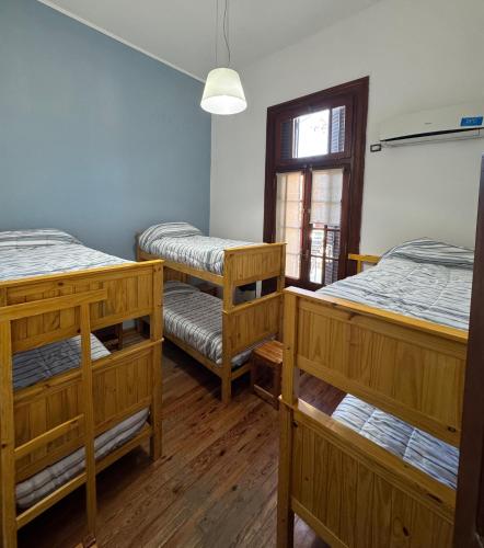 een kamer met 3 stapelbedden en een raam bij Alojamiento Zona Parque in Paraná