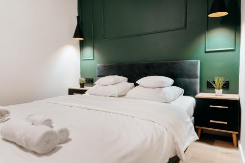 ein Schlafzimmer mit einem großen Bett mit weißen Laken und Kissen in der Unterkunft Lucia in Jarosław