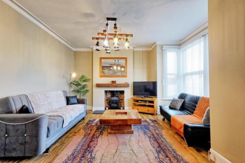 a living room with a couch and a tv at Cosy 2 Bedroom Flat Near Westcliff On Sea Beach & Hamlet Court Road in Southend-on-Sea