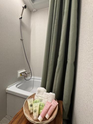 een badkamer met een douchegordijn en een mand met handdoeken bij Little Foot RV in Klamath