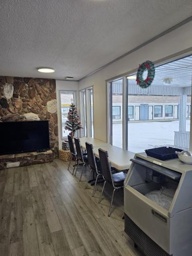 Howard Johnson by Wyndham Edson في ايدسون: غرفة معيشة مع طاولة وكراسي وتلفزيون