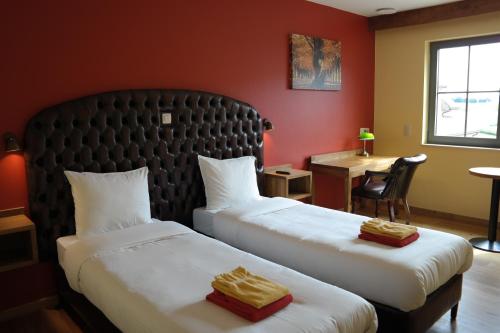 a hotel room with two beds and a desk at Country Lodge Hotel Moriaanshoofd in Oudenaarde