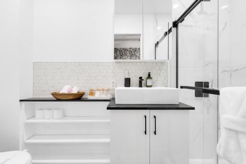 un bagno bianco con lavandino e doccia di Downtown Penthouse 2 Level-4BDRS-8Guests a Montréal