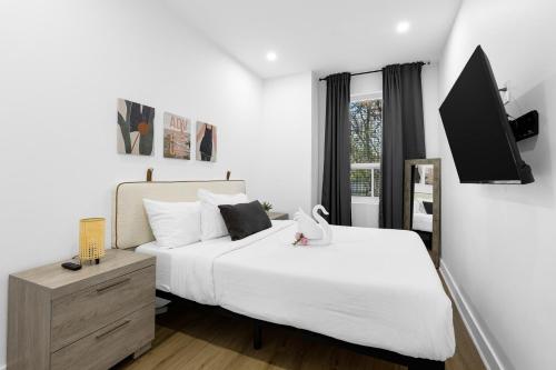 una camera da letto con due letti e una TV a parete di Downtown Penthouse 2 Level-4BDRS-8Guests a Montréal