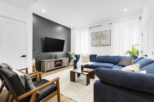 a living room with a blue couch and a tv at Boutique 4BR Luxury Residence 2 Floors Mile-End St-Laurent in Montréal